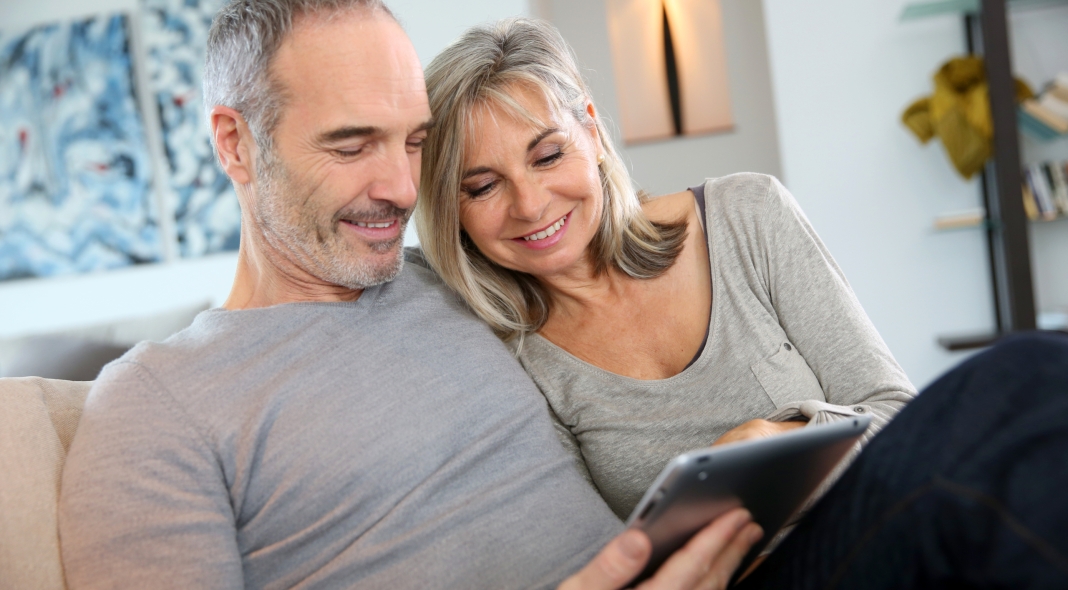 Mature couple at home websurfing with tablet